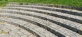Semicircular steps of the amphitheater. Wide staircase made of stone blocks or bricks. Uneven bricks. The old steps are circular Royalty Free Stock Photo