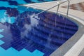 Semicircular steps of blue colour in the large pool with clear water