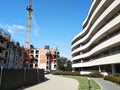 The semicircular white building with curved balconies and terraces on the background of blue sky. modern construction of houses