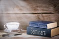 Seminars and Further Training. Stack of books on wooden desk