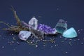 Semiprecious stones: amethyst, rhinestone, smoky quartz, fluorite, aquamarine and heather branch on a dark background