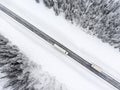 Semitrailer truck and lorry driving from the opposite direction on slippery winter asphalt highway, top view from drone