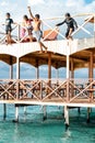 Semporna, Malaysia - November 26, 2019: Kids jumping off  from the second floor terrace into the sea. Having fun on a school Royalty Free Stock Photo