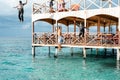 Semporna, Malaysia - November 26, 2019: Kids jumping off  from the second floor terrace into the sea. Having fun on a school Royalty Free Stock Photo