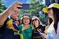 Senator pre-candidate Nise Yamaguchi smiling taking a selfie in the sun with voters on Paulista avenue