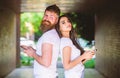 Send provocative message. Couple ignore real communication. Couple chatting smartphones. Girl and bearded man stand back Royalty Free Stock Photo