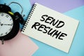 Send Resume text written on notepad with alarm clock flat lay on multicolor pastel background Royalty Free Stock Photo