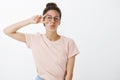 Sending positive vibes. Joyful confident and charismatic stylish woman in t-shirt and round glasses showing peace sign Royalty Free Stock Photo