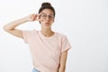 Sending positive vibes. Joyful confident and charismatic stylish woman in t-shirt and round glasses showing peace sign