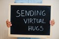 Sending virtual hugs. Coronavirus concept. Boy hold inscription on the board Royalty Free Stock Photo