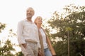 Senior active caucasian couple holding hands looks happy and carefree in the park in the afternoon autumn sunlight with copy space