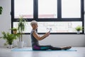 Senior active woman using smart phone at home after practicing yoga Royalty Free Stock Photo