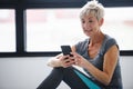 Senior active woman using smart phone at home after practicing yoga Royalty Free Stock Photo