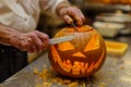 senior adult carving a traditional jackolantern with a knife