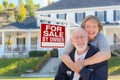 Senior Adult Couple in Front of Real Estate Sign, House Royalty Free Stock Photo