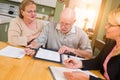 Senior Adult Couple Going Over Documents in Their Home with Agent At Signing Royalty Free Stock Photo