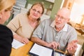 Sweet Senior Adult Couple Going Over Documents in Their Home with Agent At Signing Royalty Free Stock Photo