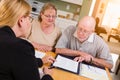 Senior Adult Couple Going Over Documents in Their Home with Agent At Signing Royalty Free Stock Photo