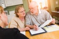 Senior Adult Couple Going Over Documents in Their Home with Agent At Signing Royalty Free Stock Photo