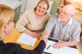 Senior Adult Couple Going Over Documents in Their Home with Agent At Signing Royalty Free Stock Photo