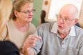 Upset Senior Adult Couple Going Over Documents in Their Home with Agent At Signing Royalty Free Stock Photo