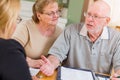 Angry Senior Adult Couple Going Over Documents in Their Home with Agent At Signing Royalty Free Stock Photo