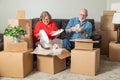 Smiling Senior Couple Packing or Unpacking Moving Boxes