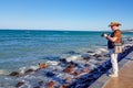 Senior adult male photographer standing on coastal boardwalk, taking photo Royalty Free Stock Photo