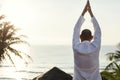 Senior adult practicing yoga near the beach