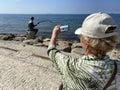 Senior adventure is ageless woman with a mobile phone take a photo sights of Albania Durres near sea beach in summer day. Summer