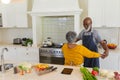 Senior african american couple dancing together in kitchen smiling Royalty Free Stock Photo