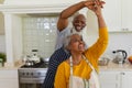 Senior african american couple dancing together in kitchen smiling Royalty Free Stock Photo