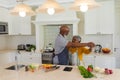 Senior african american couple dancing together in kitchen smiling Royalty Free Stock Photo