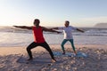 Senior african american couple performing stretching exercise together at the beach