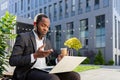 A senior African American male businessman is talking to his team via video call. Sitting near the office center on a Royalty Free Stock Photo