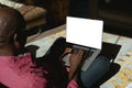 Senior african american man in modern sunny living room working on laptop