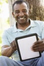 Senior African American Man In Park Using Tablet Computer Royalty Free Stock Photo