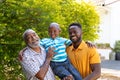 Senior African American man spending time with his son and his grandson in the garden Royalty Free Stock Photo