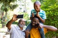 Senior African American man spending time with his son and his grandson in the garden Royalty Free Stock Photo