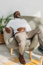 senior african american man in stylish outfit sleeping in armchair. Royalty Free Stock Photo