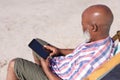 Senior african american man using digital tablet at the beach Royalty Free Stock Photo