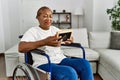 Senior african american woman looking photo sitting on wheelchair at home