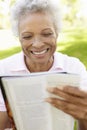 Senior African American Woman Reading Magazine In Park Royalty Free Stock Photo