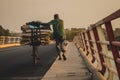 African pushing a bike over a bridge