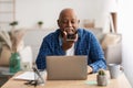 Senior African Man Using Voice Search On Smartphone In Office