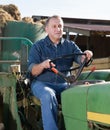 Senior aged man working on small farm tractor Royalty Free Stock Photo