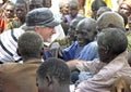 Senior aid relief volunteer smiling laughing with old African men Uganda, Africa