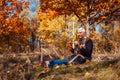 Senior alone man sitting in park picking yellow leaves. Retired man relaxing outdoors enjoying autumn nature Royalty Free Stock Photo