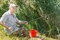 Senior angler fishing from a reed bank