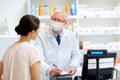 Senior apothecary in mask and customer at pharmacy Royalty Free Stock Photo